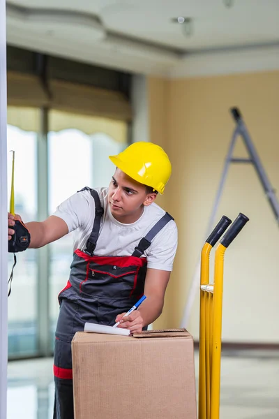 Entrega hombre tomando dimensiones con cinta métrica —  Fotos de Stock