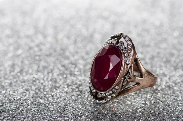 Sieraden ring tegen glanzende achtergrond — Stockfoto