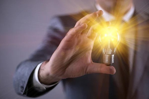 Young businessman with light bulb in idea concept — Stock Photo, Image