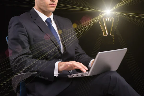 Молодой бизнесмен с концепцией ноутбука и лампы — стоковое фото