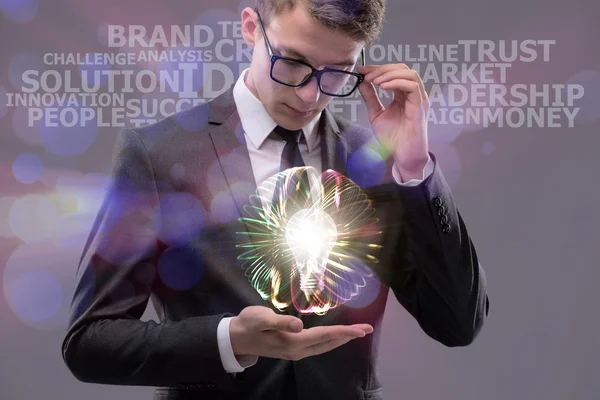 Young businessman with light bulb in idea concept — Stock Photo, Image