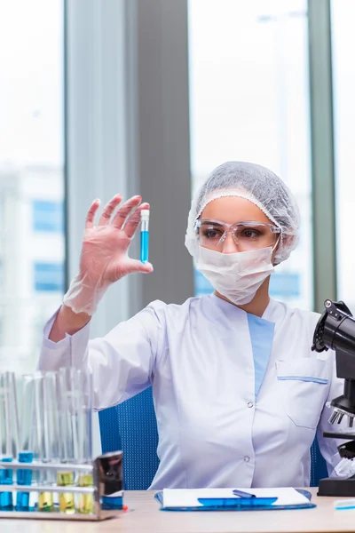 Jovem estudante trabalhando com soluções químicas em laboratório — Fotografia de Stock