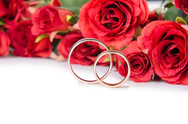 Anneaux de mariage et fleurs isolés sur fond blanc — Photo