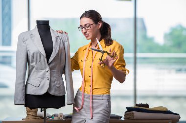 Kadın terzi yeni elbiseler üzerinde çalışıyor.