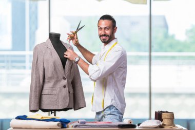 Genç terzi yeni kıyafet tasarımı üzerinde çalışıyor.