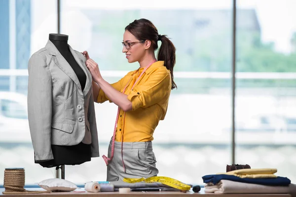 Mulher alfaiate trabalhando em roupas novas — Fotografia de Stock