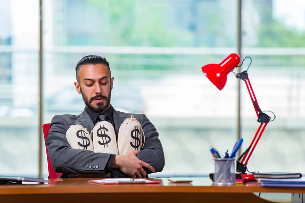 Empresário feliz com sacos de dinheiro no escritório — Fotografia de Stock