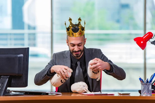 Businessman with crown and money sacks in the office — Stock Photo, Image