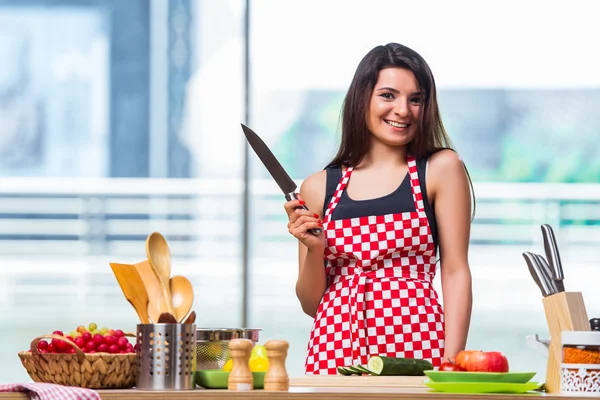 Ung kvinna förbereda sallad i köket — Stockfoto