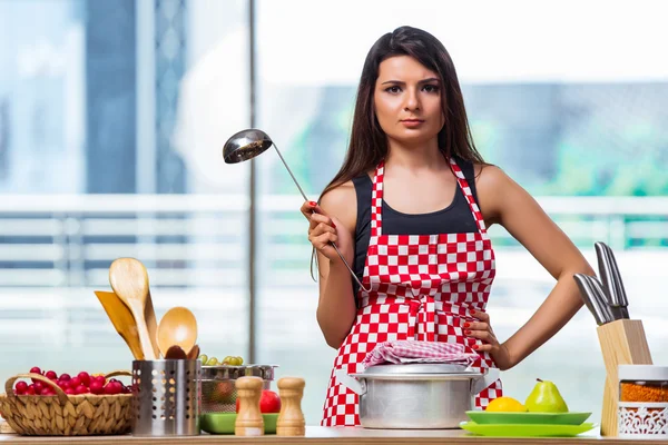 Vrouwelijke kok bereiden soep in fel verlicht keuken — Stockfoto