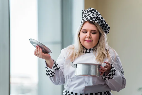 Female cook preparing soup in brightly lit kitchen — Stock Photo, Image