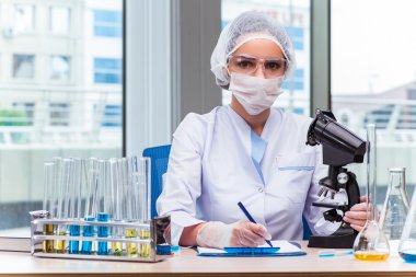 Genç öğrenci laboratuarında kimyasal çözümleri ile çalışma