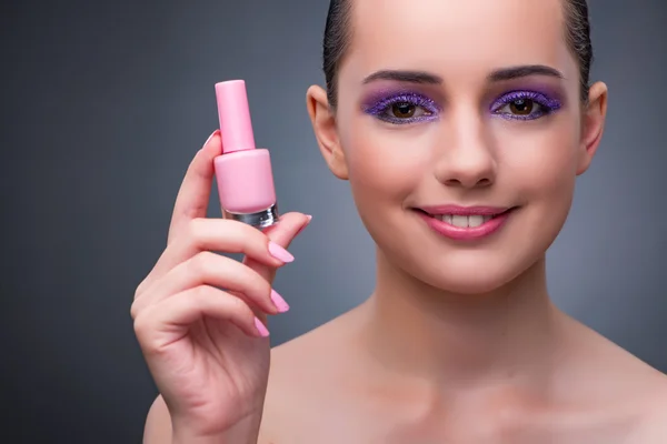 Mujer joven con lápiz labial en concepto de belleza — Foto de Stock