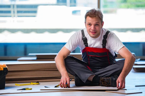 Man lägga laminat golv i konstruktion koncept — Stockfoto