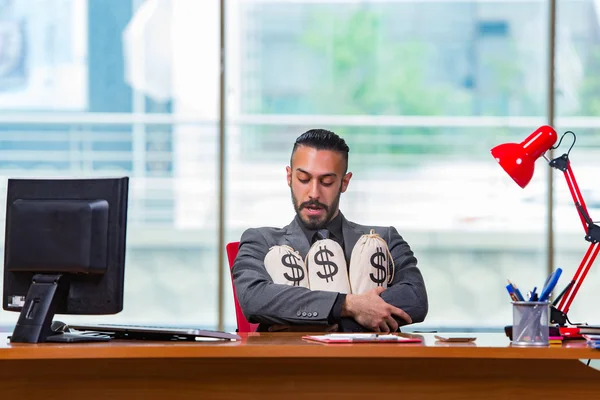 Empresário feliz com sacos de dinheiro no escritório — Fotografia de Stock