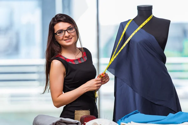 Mujer sastre trabajando en ropa nueva — Foto de Stock