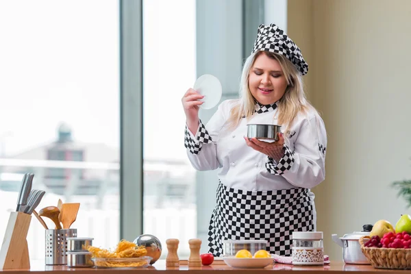 Female cook preparing soup in brightly lit kitchen — Stock Photo, Image