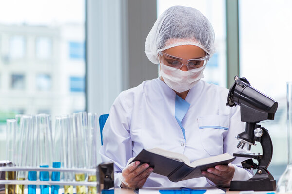 Молодой студент, работающий с химическими растворами в лаборатории
