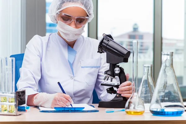 Estudiante joven trabajando con soluciones químicas en laboratorio — Foto de Stock