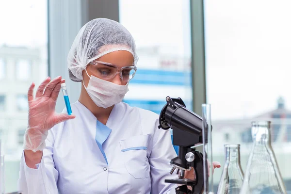 Jovem estudante trabalhando com soluções químicas em laboratório — Fotografia de Stock