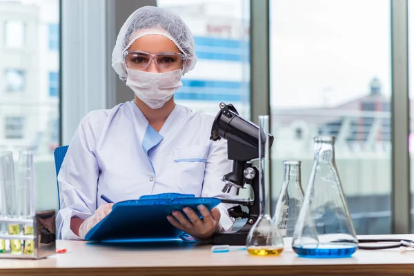 Jonge student werkt met chemische oplossingen in lab — Stockfoto