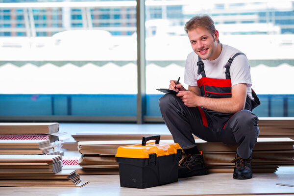 Man laying laminate flooring in construction concept