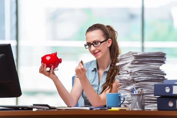 Junge Geschäftsfrau mit Sparschwein im Büro — Stockfoto