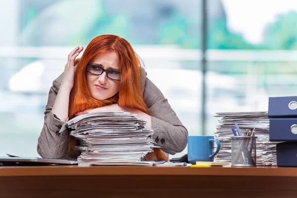 Stressed businesswoman with stack of papers