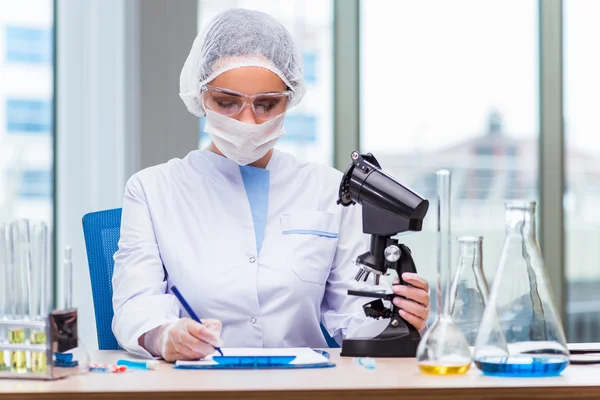 Estudiante joven trabajando con soluciones químicas en laboratorio — Foto de Stock