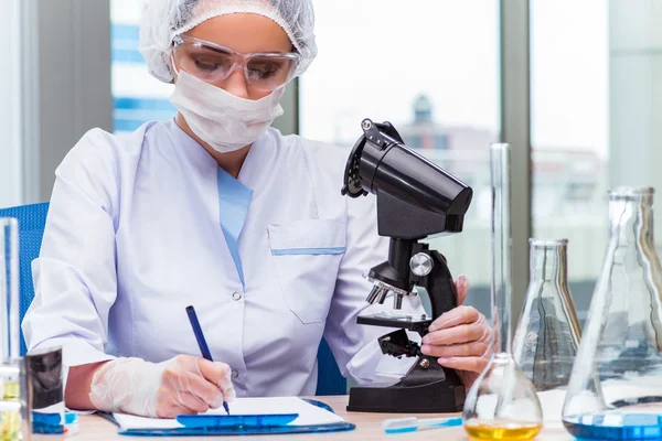 Estudiante joven trabajando con soluciones químicas en laboratorio — Foto de Stock