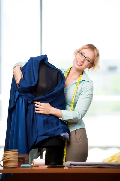 Mulher alfaiate trabalhando em roupas novas — Fotografia de Stock