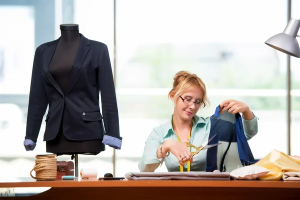 Mulher alfaiate trabalhando em roupas novas — Fotografia de Stock