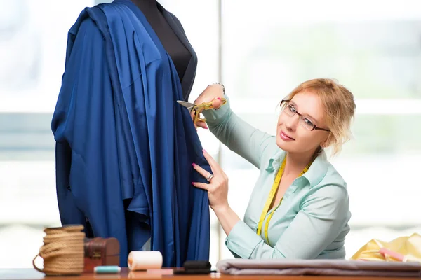 Mulher alfaiate trabalhando em roupas novas — Fotografia de Stock