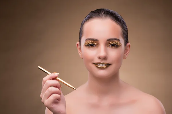 Kobieta z złote pióro w koncepcja moda — Zdjęcie stockowe