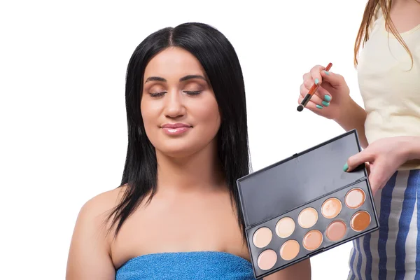 Mujer joven consiguiendo maquillaje aislado en blanco — Foto de Stock