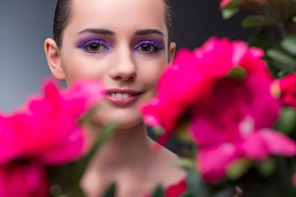 Ung kvinna med blommor i skönhet koncept — Stockfoto