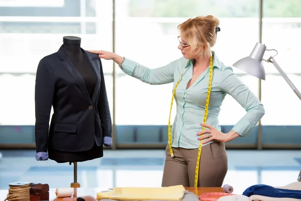 Mulher alfaiate trabalhando em roupas novas — Fotografia de Stock