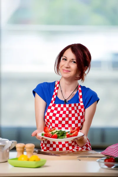 Kvinna förbereder sallad i köket — Stockfoto