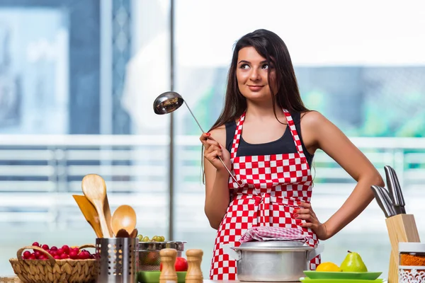 Vrouwelijke kok bereiden soep in fel verlicht keuken — Stockfoto