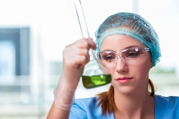 Jovem estudante trabalhando com soluções químicas em laboratório — Fotografia de Stock