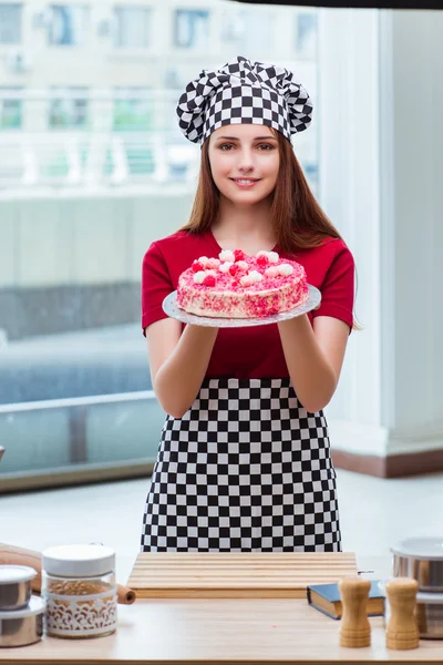 Jovem dona de casa assar bolo na cozinha — Fotografia de Stock