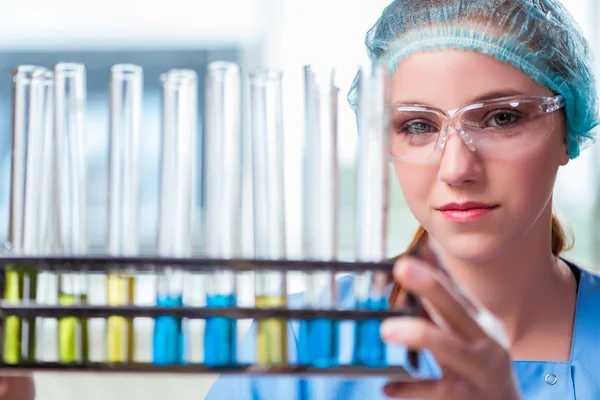 Jovem estudante trabalhando com soluções químicas em laboratório — Fotografia de Stock