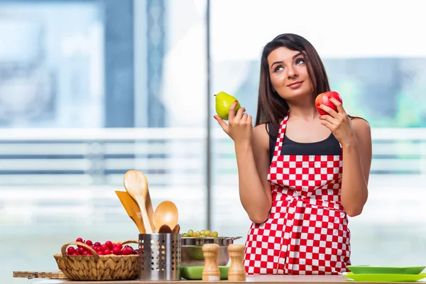 Jovem cozinheiro com frutas na cozinha — Fotografia de Stock