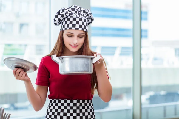 Молода домогосподарка готує суп на кухні — стокове фото