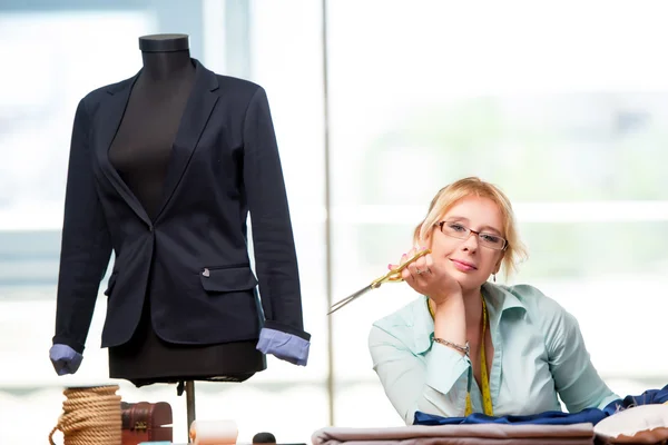 Mulher alfaiate trabalhando em roupas novas — Fotografia de Stock