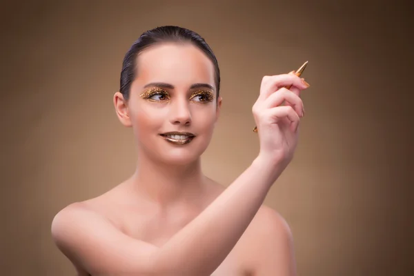 Mujer con pluma dorada en concepto de moda —  Fotos de Stock