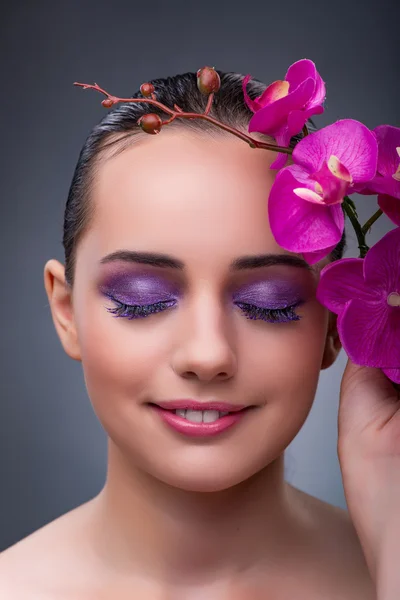 Giovane donna in concetto di bellezza con fiore di orchidea — Foto Stock