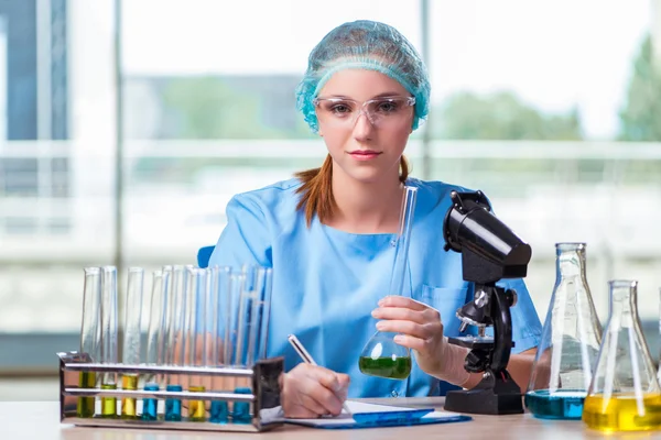 Estudiante joven trabajando con soluciones químicas en laboratorio — Foto de Stock