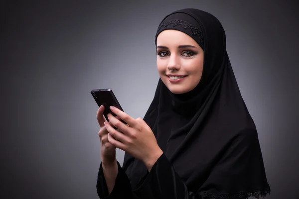 Muslimische Frau in schwarzem Kleid vor dunklem Hintergrund — Stockfoto