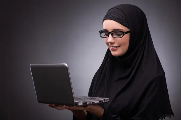 Muslim woman in black dress against dark background — Stock Photo, Image